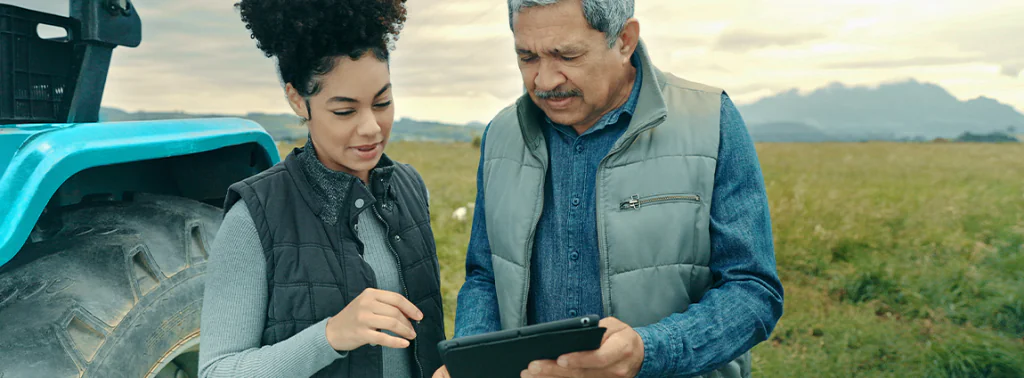 pessoas no campo próximas a um trator da frota monitorando via 5G