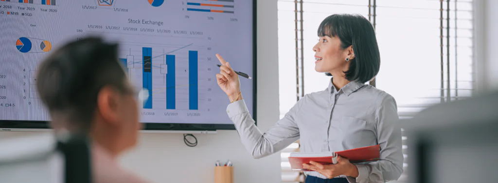 mulher apresentando gráficos analisados para colega de trabalho