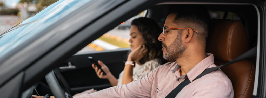 homem e mulher dentro do carro dirigindo a trabalho