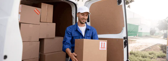 Um funcionário carregando um caixa de mercadoria Um funcionário carregando um caixa de mercadoria