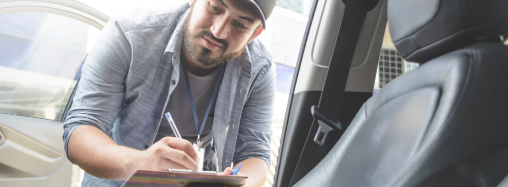 entregador fazendo um checklist dentro do carro da empresa