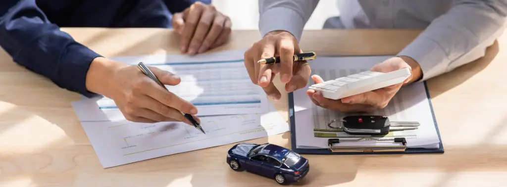 duas pessoas calculando o seguro para frota de carro