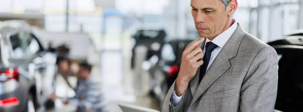 gestor de frota segurando tablet ao lado do carro