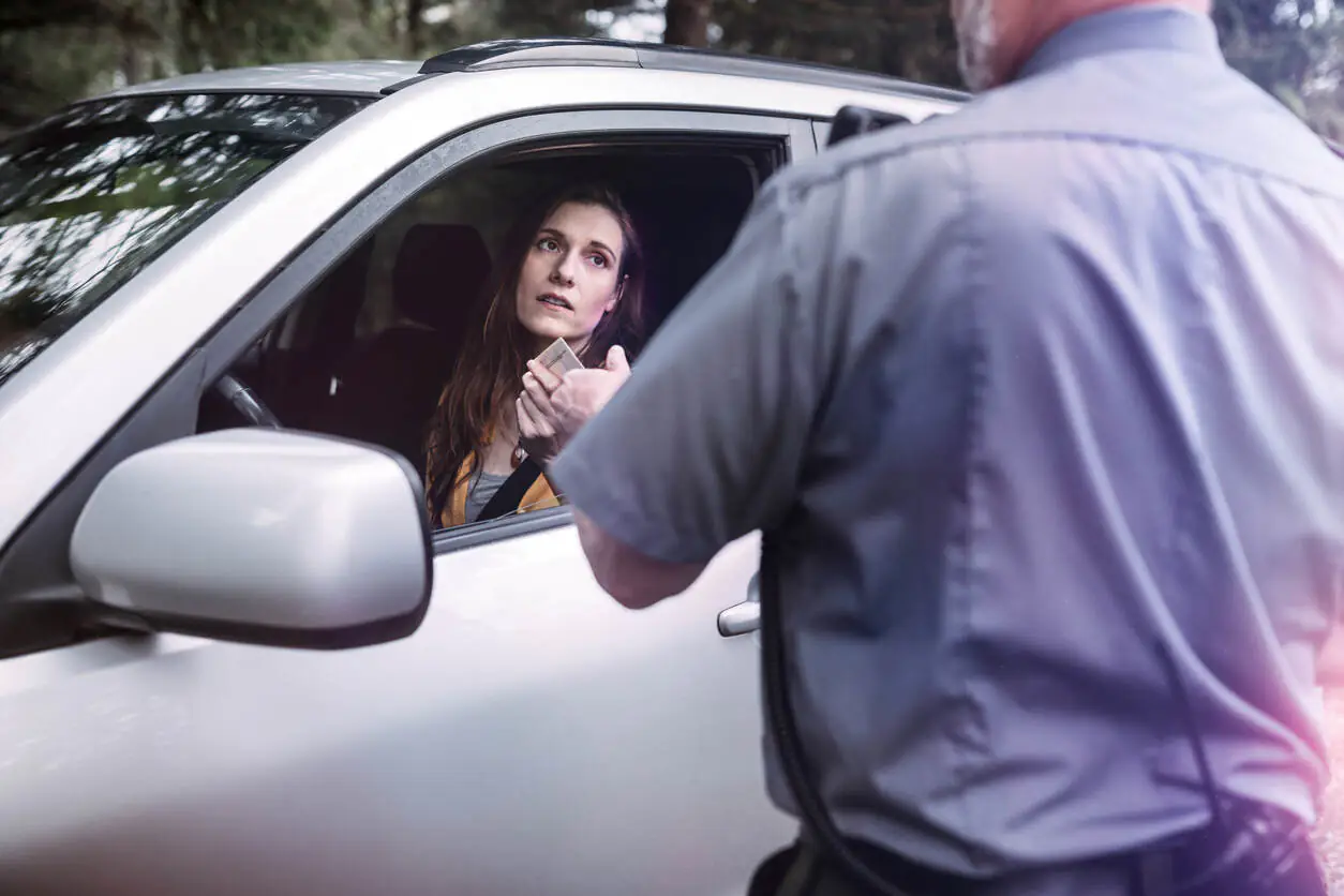Mulher dentro do carro levando uma multa de trânsito Mulher dentro do carro levando uma multa de trânsito