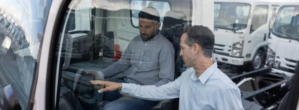 Consultor mostrando um caminhão truck a um homem