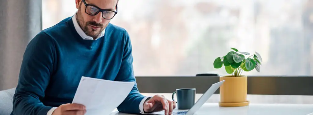 Homem usando notebook para pagar multa