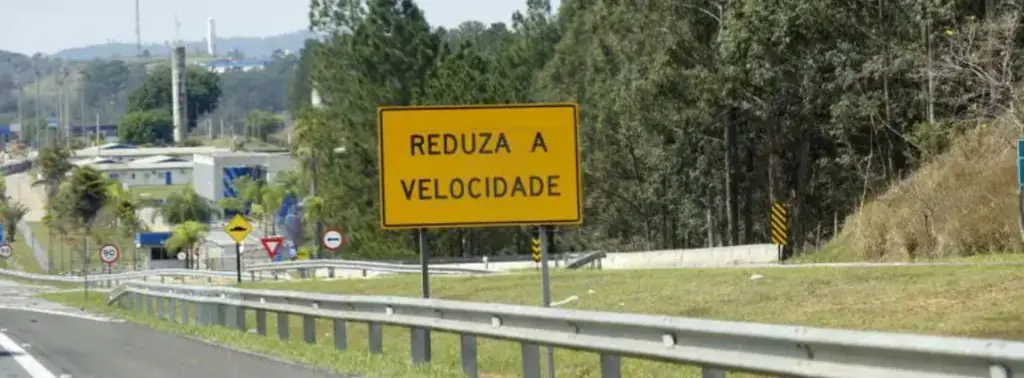 Placa na rodovia alertando para reduzir a velocidade