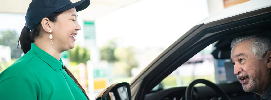 frentista com motorista em um posto de combustível frentista com motorista em um posto de combustível