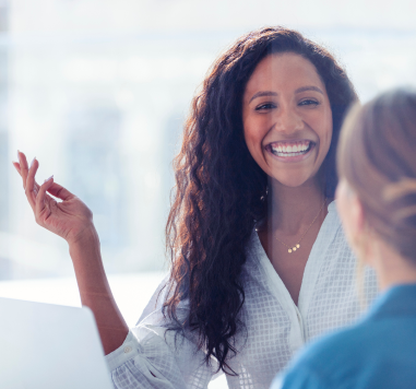 Imagem de duas mulheres conversando e uma está sorrindo